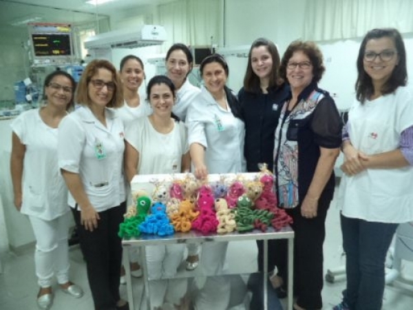 A coordenadora de enfermagem da Santa Casa de Sertãozinho, Liliane Passarelli e a equipe de enfermagem da UTI Neo Natal recebem a doação de polvos de crochê da munícipe Aline Heck Mafra e sua mãe, Natalina Ap. Heck